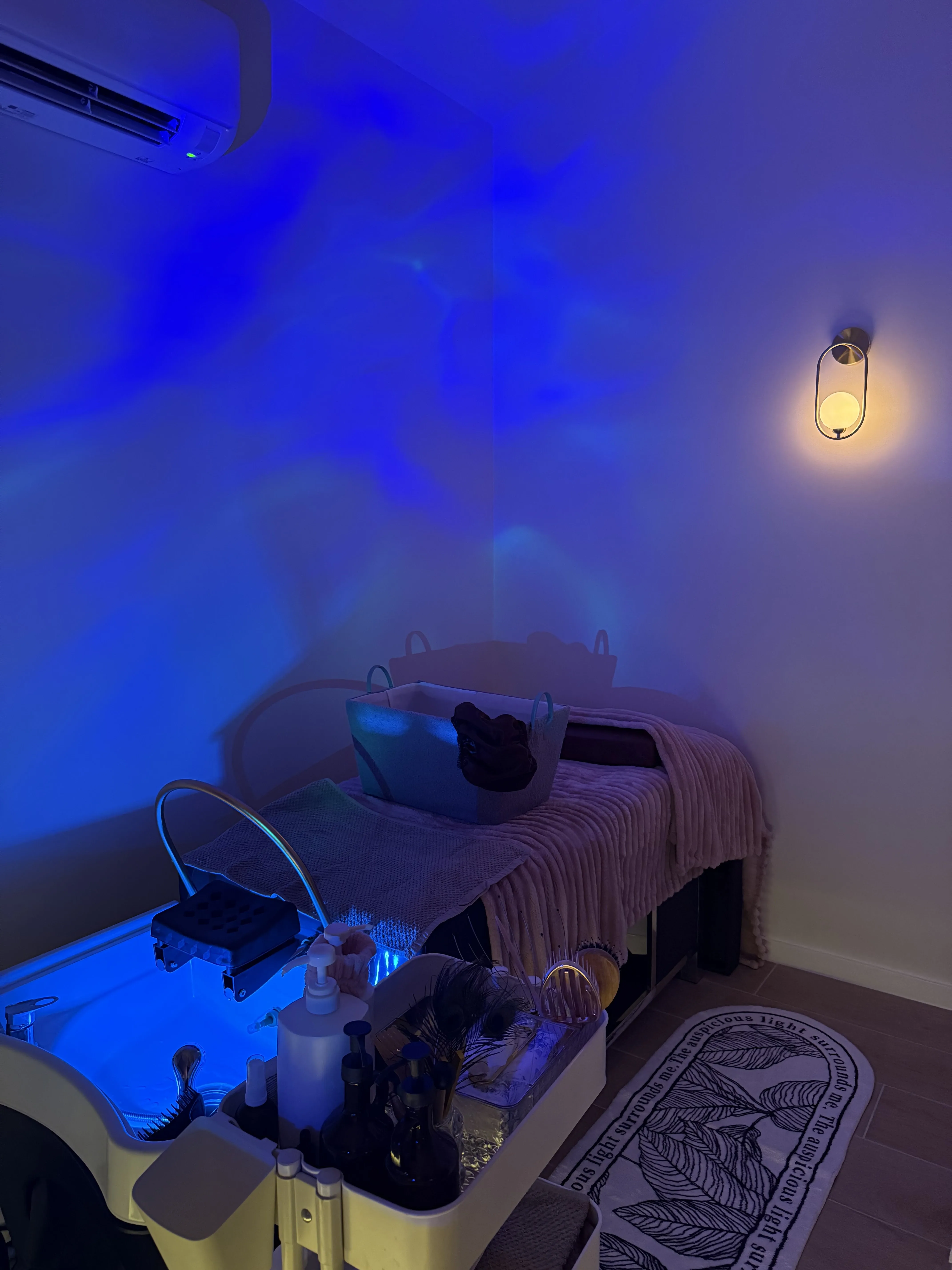 Treatment bed and basin bathed in blue aurora light — a private sanctuary