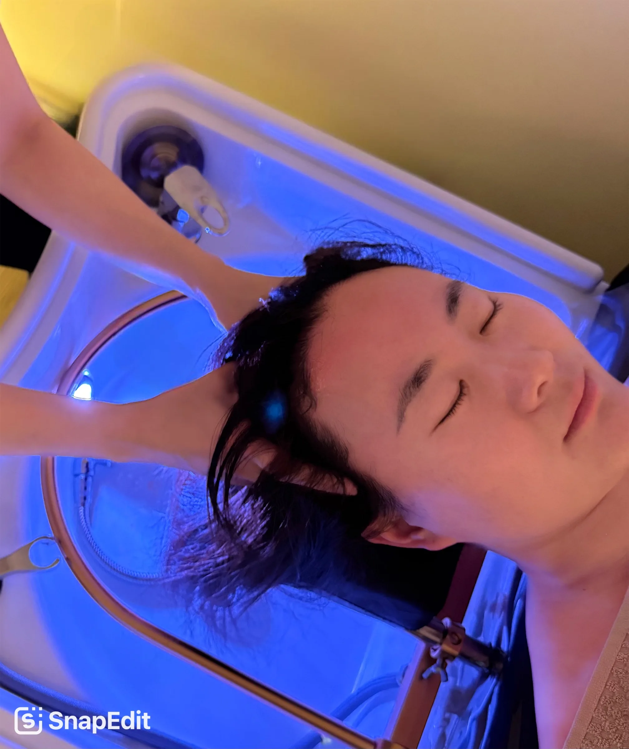 Client resting in the water-halo basin under soft blue light