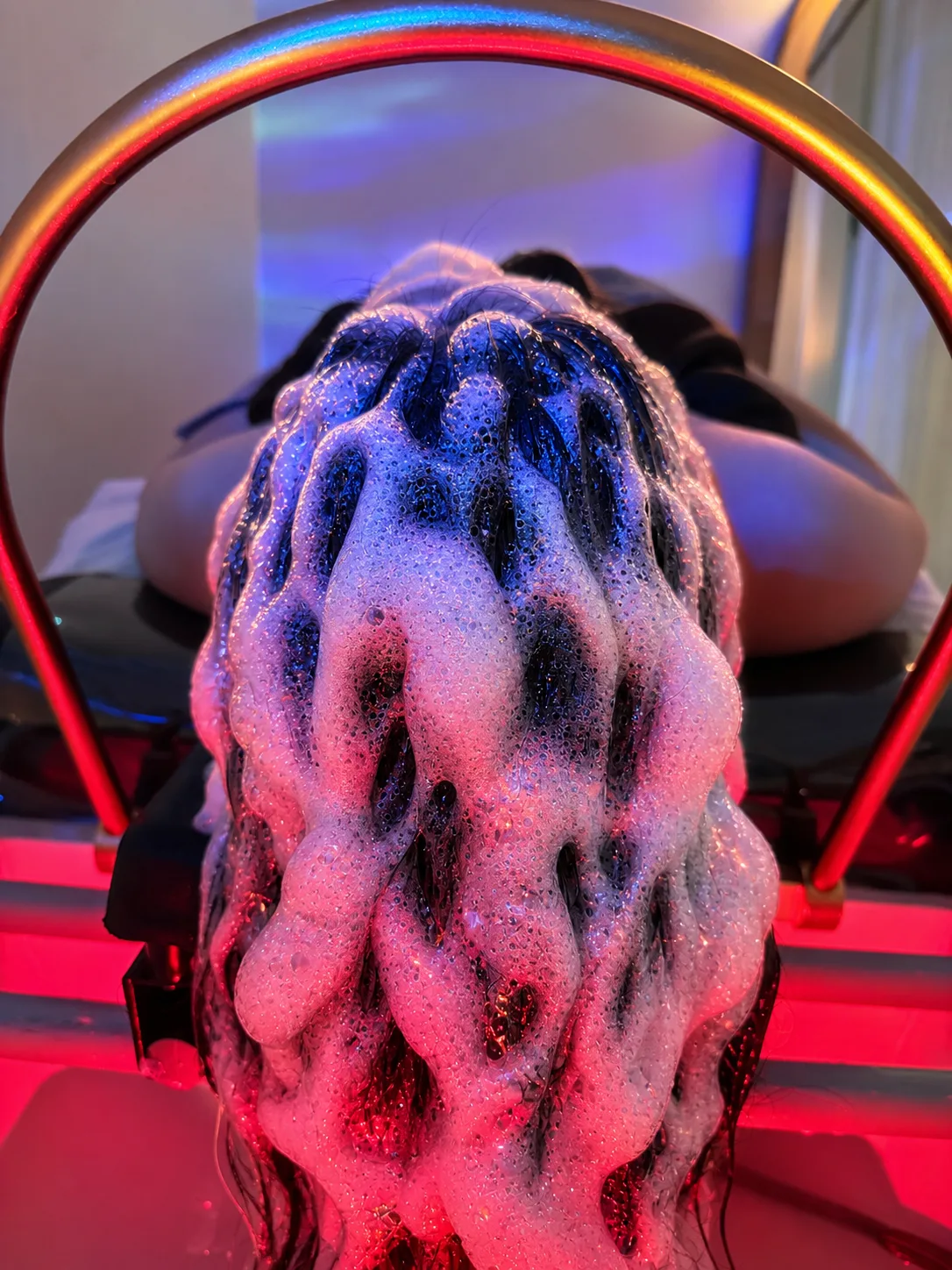 Deep scalp cleanse — rich foam under rose and blue light
