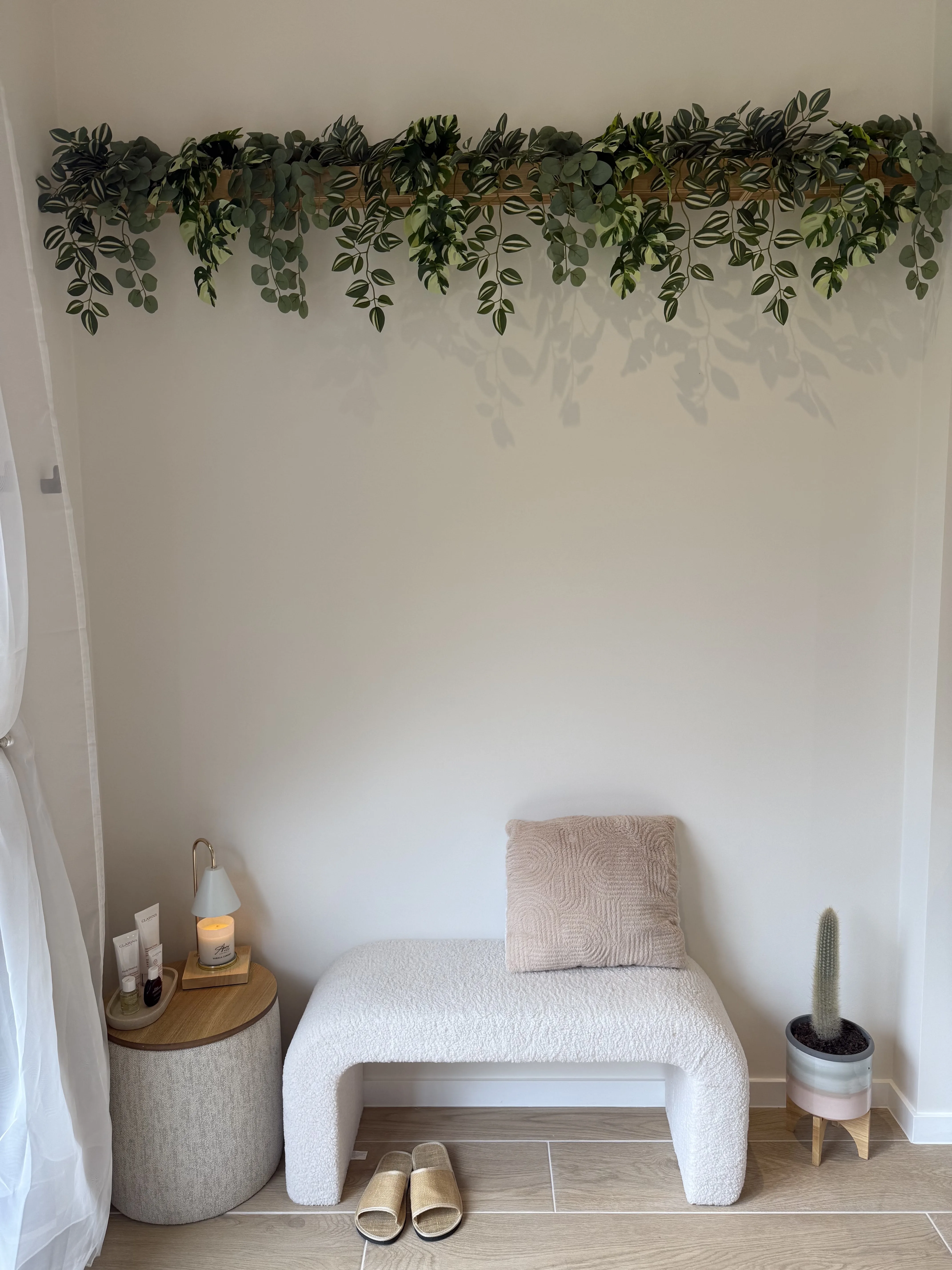Bright rest corner with trailing greenery, bench and Clarins products